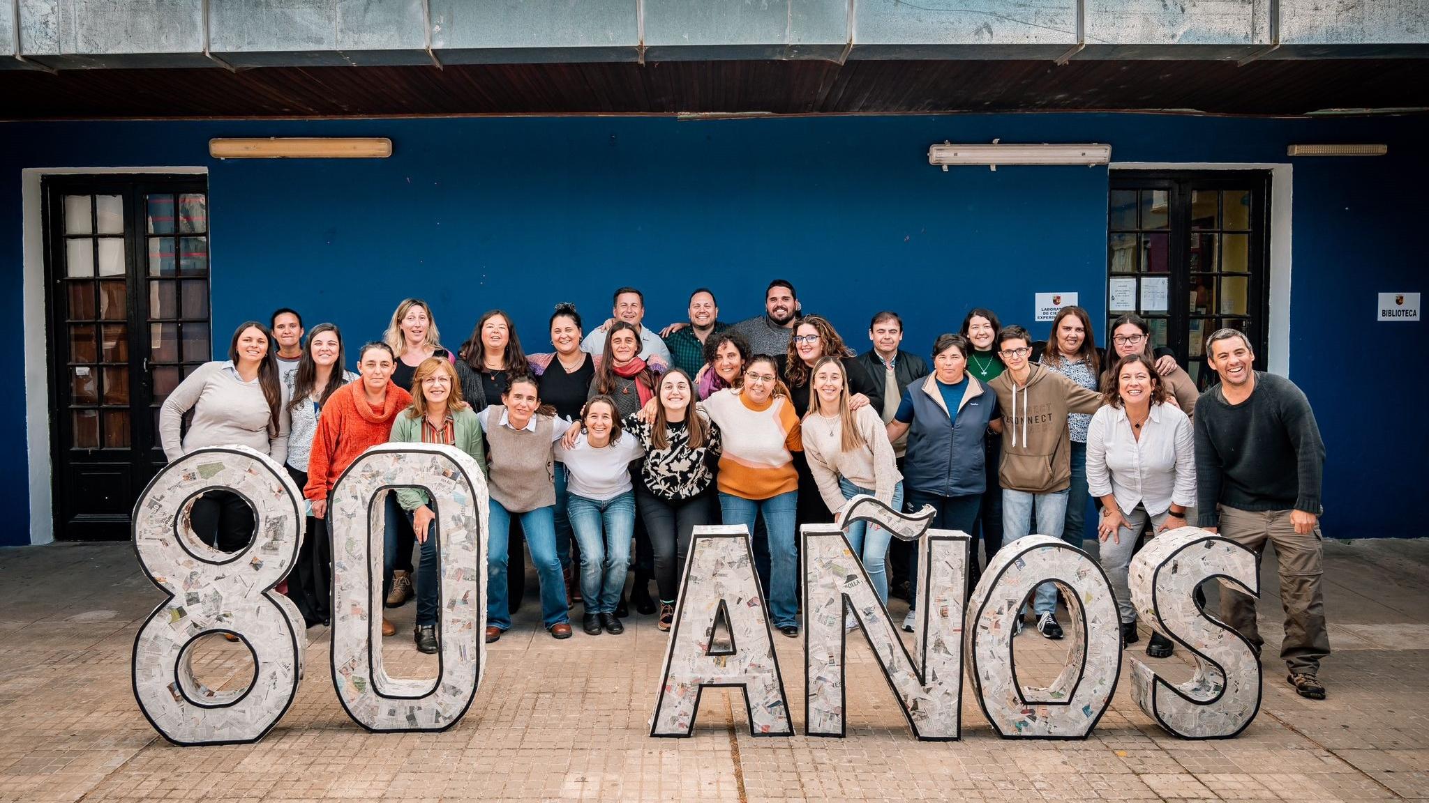 comunidad del liceo de aiguá con cartel de ochenta años